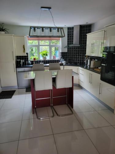 a kitchen with a table and some white cabinets at Tullyvinney Lodge in Raphoe