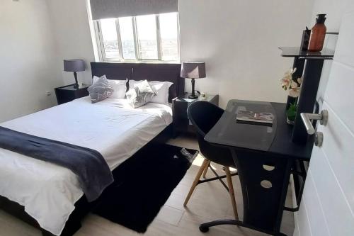 a small bedroom with a bed and a desk at Sweet Home in Maputo
