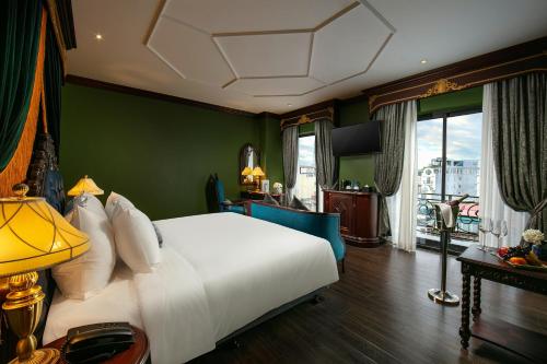 a bedroom with a white bed and a green wall at Le Chanvre Hanoi Hotel & Spa in Hanoi