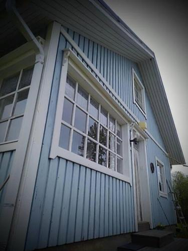 uma casa azul com uma janela do lado em Yösija luonnon kupeessa em Kuhmo