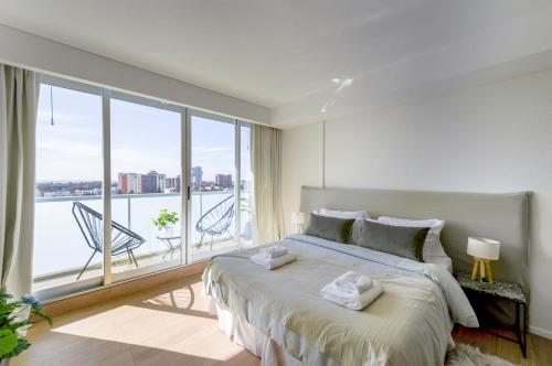 1 dormitorio con cama grande y ventana grande en Fliphaus Be Libertador - Lux 3 Pax Loft 11-20 en Buenos Aires