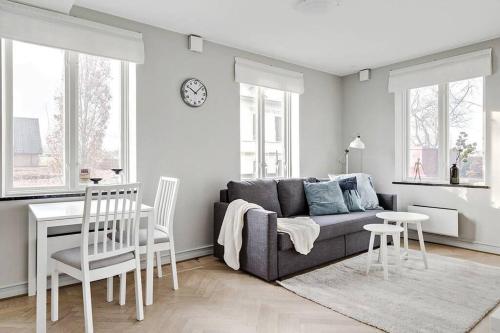 a living room with a couch and a table and chairs at Bright apartment in park environment in Lund