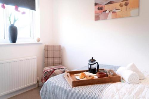a tray of food sitting on top of a bed at Modern 2 Bed Home Close To Village Centre in Kidlington