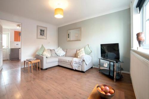 a living room with a white couch and a television at Modern 2 Bed Home Close To Village Centre in Kidlington