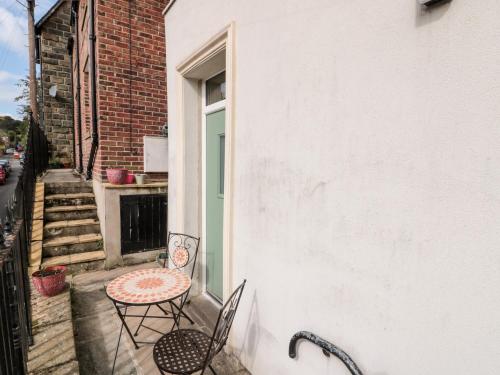 a patio with a table and chairs on the side of a building at Nutshell in Whitby