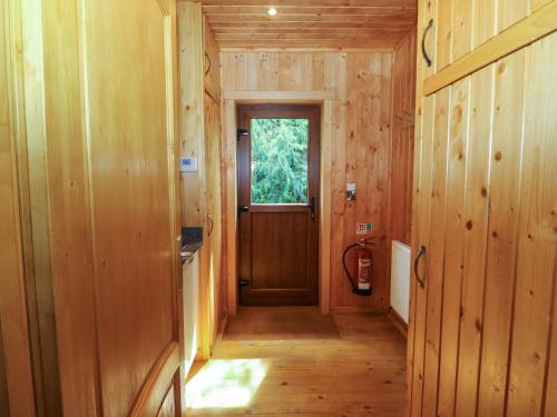 - un couloir avec une porte dans une maison en bois dans l'établissement Barn Shelley Lodge, à Copplestone