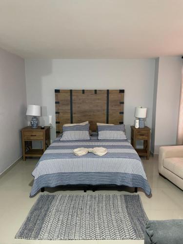 a bedroom with a large bed with a pair of glasses on it at Acuarama Studio parque del perro in Cali