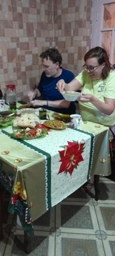 Guesthouse Irina Family Hotel في Tsvirmi: مجموعة من الناس يجلسون على طاولة مع كعكة