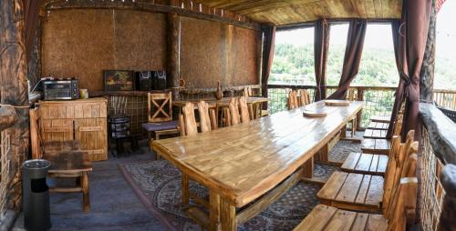uma sala de jantar com uma mesa de madeira e cadeiras em Dom Adonis em Dilijan