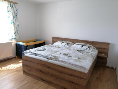 a bed in a room with a wooden bed frame at Apartment Anna im Mostviertel in Seitenstetten Markt