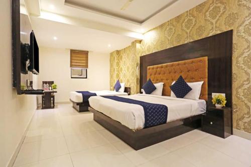 ein Hotelzimmer mit 2 Betten und einem TV in der Unterkunft Iconic Stay Delhi Airport in Neu-Delhi