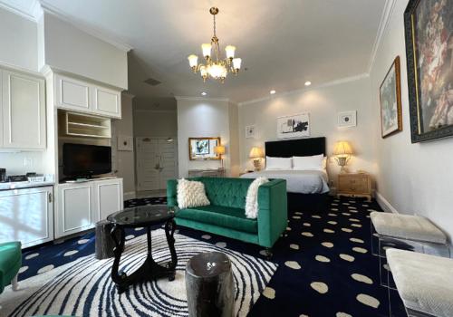 uma sala de estar com uma cama e um sofá verde em Sterling Hotel em Sacramento
