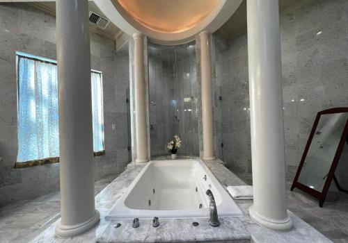 a large bathroom with a bath tub with columns at Sterling Hotel in Sacramento