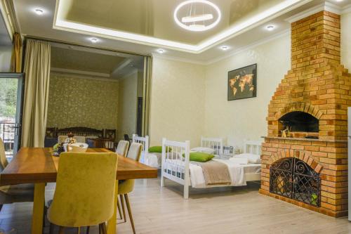 a living room with a dining table and a brick fireplace at Dom Adonis in Dilijan