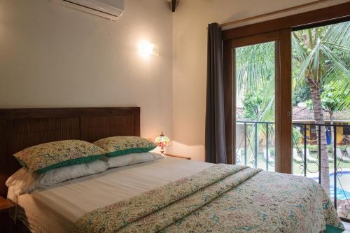a bedroom with a bed and a large window at Villas Macondo in Tamarindo