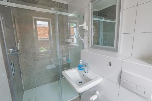 a bathroom with a sink and a glass shower at sehusa living in Seesen