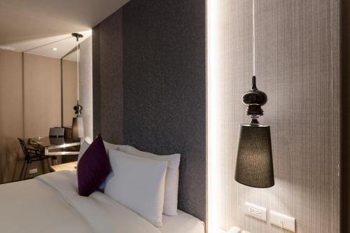 a hotel room with a bed and a lamp at Green Hotel in Magong
