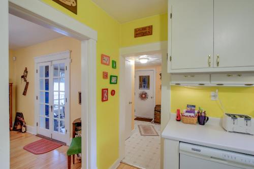 a kitchen with yellow walls and a white counter top at Historic Home with Sunroom - 5 Mi to Lambeau Field! in De Pere
