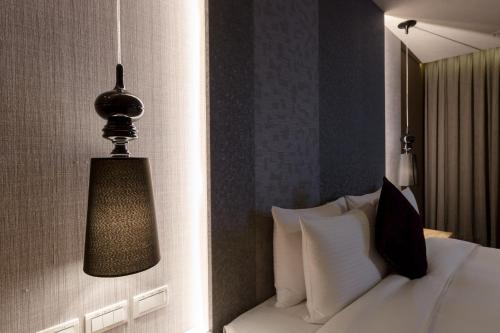 a bedroom with a bed and a lamp on the wall at Green Hotel in Magong
