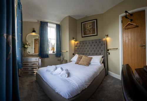 a bedroom with a large bed with towels on it at The Lower Buck Inn in Clitheroe