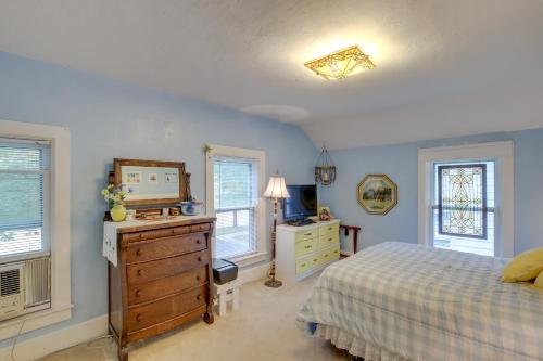 um quarto com uma cama, uma cómoda e janelas em Historic Home with Sunroom - 5 Mi to Lambeau Field! em De Pere