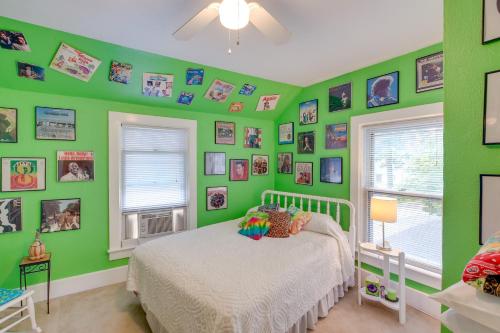 a bedroom with green walls and a bed and windows at Historic Home with Sunroom - 5 Mi to Lambeau Field! in De Pere