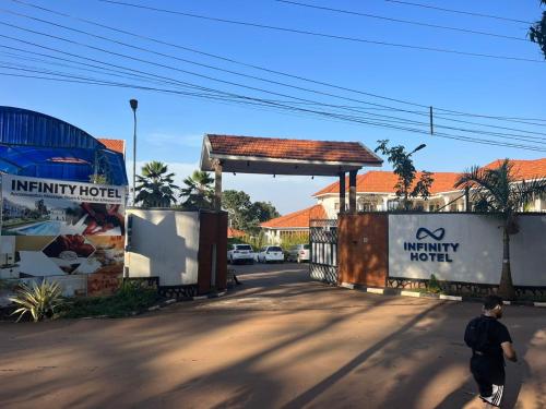 a man walking down a street next to a gas station at Infinity Hotel Kampala in Kampala