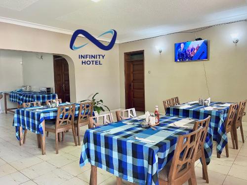 a restaurant with blue and white checkered tables and chairs at Infinity Hotel Kampala in Kampala