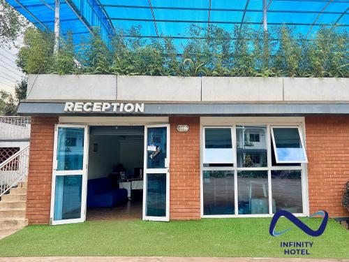 a red brick building with a reception sign on it at Infinity Hotel Kampala in Kampala