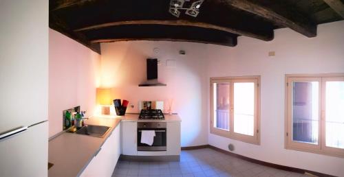 a kitchen with a sink and a stove top oven at De' Pepoli Rooms & Apartments in Bologna