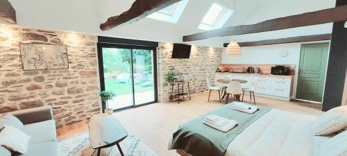 une chambre avec un lit et un mur en pierre dans l'établissement Le Clos de Squividan, à Ergué-Gabéric