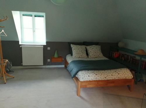 a bedroom with a bed and a window at Au fil de l'eau in Cerdon