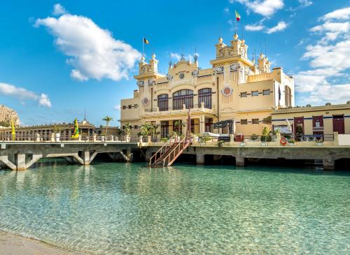 a building on a bridge over a body of water at Green House Beach in Mondello