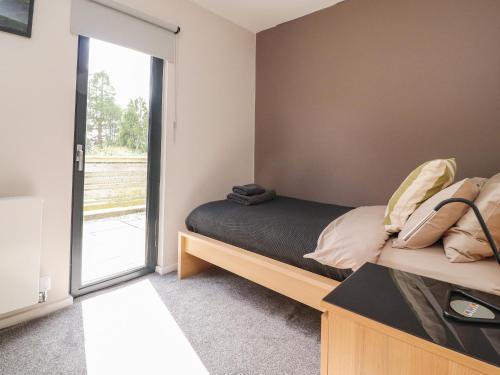 a bedroom with a bed and a sliding glass door at Underfell in Carnforth