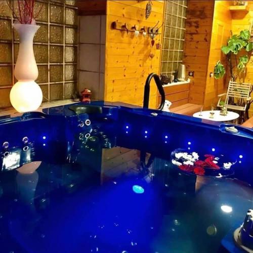 La salle de bains est pourvue d'une baignoire bleue et d'un lavabo. dans l'établissement Appartement chaleureux cosy et climatisé Karine hospitality, à Saint-Just-la-Pendue
