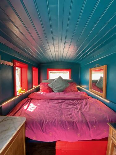 Ce lit se trouve dans un dortoir doté d'un plafond bleu. dans l'établissement Bohémienne regarde la mer., à Plogoff
