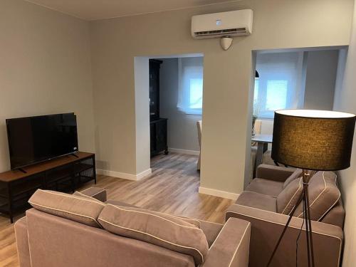 sala de estar con sofá y TV en Precioso y céntrico apartamento, en Zaragoza
