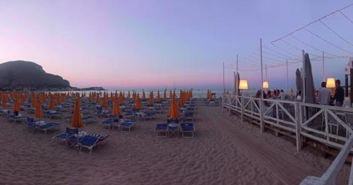 a group of chairs and umbrellas on a beach at Villebe Mondello in Mondello