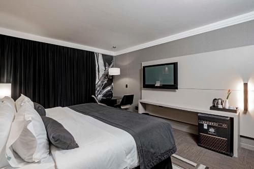 a hotel room with a bed and a flat screen tv at Full Jazz by Slaviero Hotéis in Curitiba