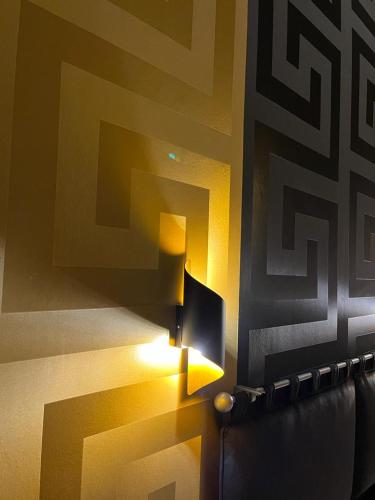 una lampada su un muro con un dipinto sopra di Golden a Barletta