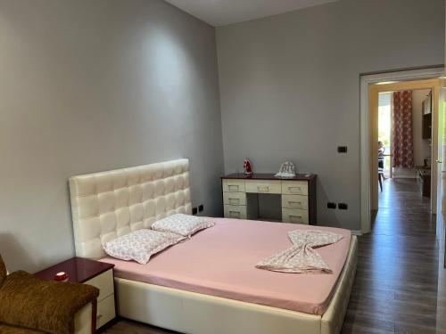 sypialnia z różowym łóżkiem i komodą w obiekcie Lukas Apartament Vollga Durres w Durrës