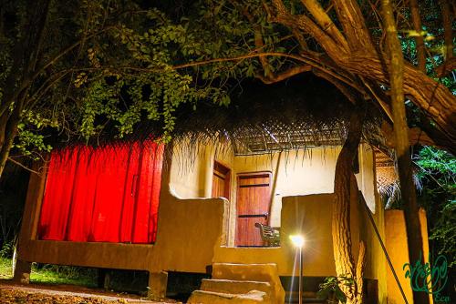 a house with a red door and a red curtain at Yala Beddegama Eco in Kataragama