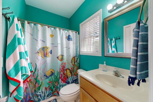 a bathroom with a fish shower curtain and a sink at Oyster Bay Villas --- 20411 Jeb Dr, Unit #36 in Rehoboth Beach