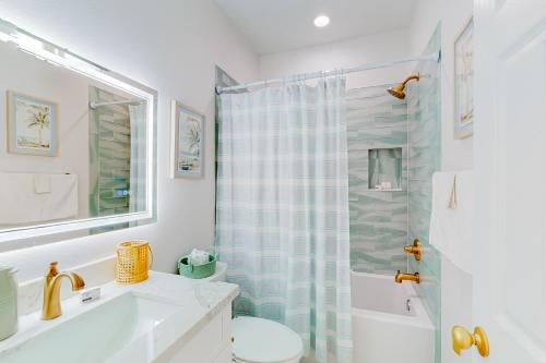 uma casa de banho com um lavatório, um WC e um chuveiro em The Purple Pelican em Galveston