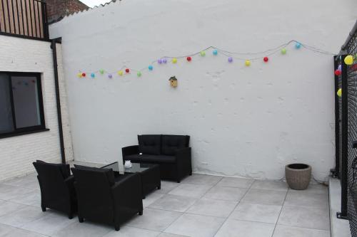 a patio with two chairs and a table and balloons at Ruim nieuwbouwappartement oostduinkerke in Oostduinkerke