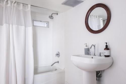 a white bathroom with a sink and a mirror at Luxury Home - Rooftop Garden - Heart of Old San Juan in San Juan