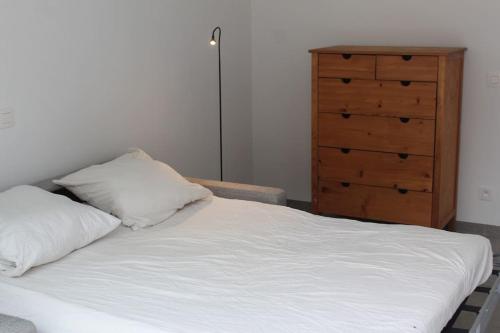 - un lit avec deux oreillers et une commode dans une chambre dans l'établissement Ruim nieuwbouwappartement oostduinkerke, à Oostduinkerke