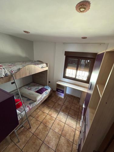 een kamer met 2 stapelbedden en een raam bij casa en la caleta salobreña in Salobreña