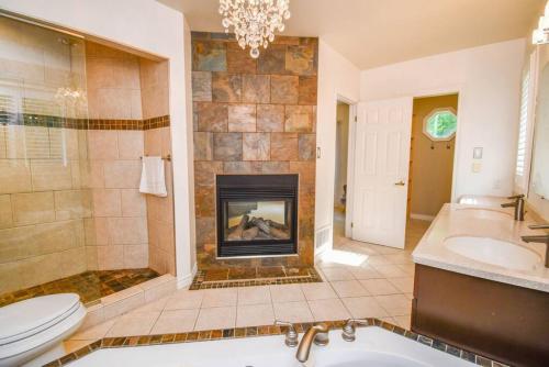 baño con chimenea, aseo y lavamanos en Casa Borealis - Hot Tub - Fire Pit - BBQ, en Orillia