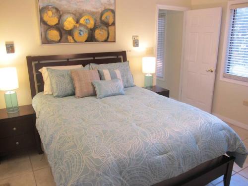 ein Schlafzimmer mit einem großen Bett mit Kissen und zwei Lampen in der Unterkunft Fabulous one bedroom in West Bay in West Bay